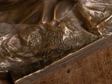 a bronze statue of a person laying on a bed
