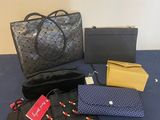 three purses and a handbag on a blue table