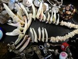 a necklace with a fish made out of bone and beads
