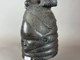a close up of a statue of a head with a bird on it