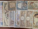 several different bank notes are laid out on a wooden table