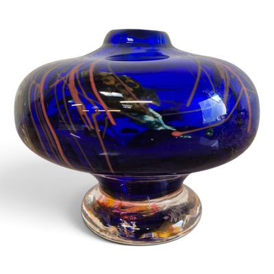 a blue vase with a bird on it sitting on a stand