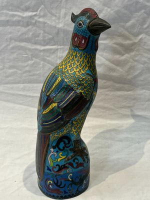 a colorful bird that is sitting on top of a vase