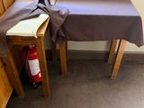 a table with a brown cloth on it next to a fire extinguisher