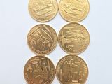 six gold coins with different designs on them on a white surface