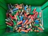 a green bin full of shotgun shells in it