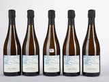 quatre bouteilles de vin sont alignées sur une surface blanche