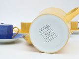 two cups and saucers are sitting next to each other on a white surface