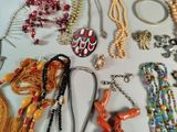 many necklaces and bracelets laid out on a table