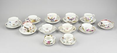 un grand nombre de tasses et de soucoupes posées sur une table
