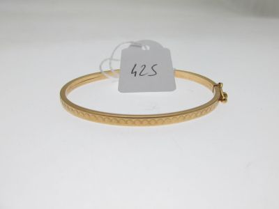 a close up of a gold bracelet with a price tag on it