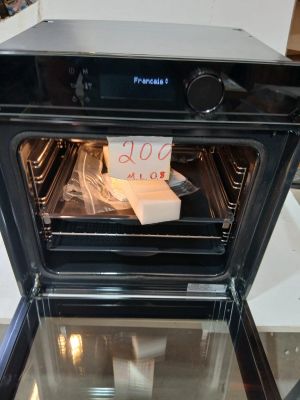 un four noir contenant une boîte de nourriture