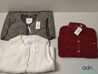 three pairs of men ' s sweaters sitting on top of a white table