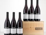 six bottles of red wine sit in front of a wooden crate