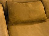 brown leather couch with two pillows and a pillow on top of it