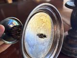 une personne qui tient un objet en argent sur une table