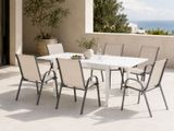 une table et des chaises blanches sur une terrasse avec vue sur l'océan