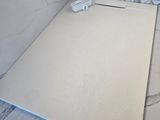 un sol en carrelage blanc sur lequel est posée une étiquette jaune