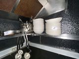 a picture of a kitchen with a lot of dishes hanging from the ceiling