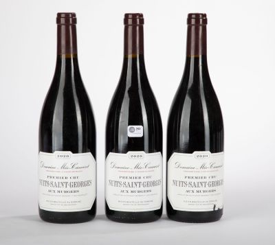 trois bouteilles de vin rouge sont alignées sur une surface blanche