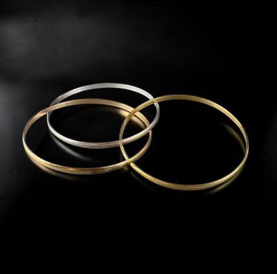 three gold and silver rings on a black background