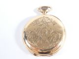 a gold pocket watch on a white surface with a white background