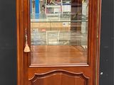 une vitrine ancienne en bois avec une porte vitrée