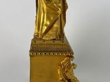 an image of a gold statue of a woman holding a crown