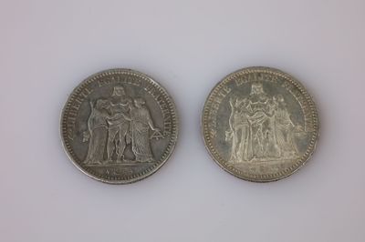 deux pièces d'argent posées côte à côte sur une surface blanche