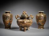three vases with designs on them sitting on a gray surface