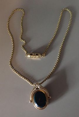 collier plaqué or avec un pendentif en pierre bleue sur une chaîne