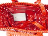 a red handbag with a cell phone inside of it