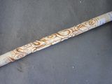 a wooden stick with a design on it sitting on a table