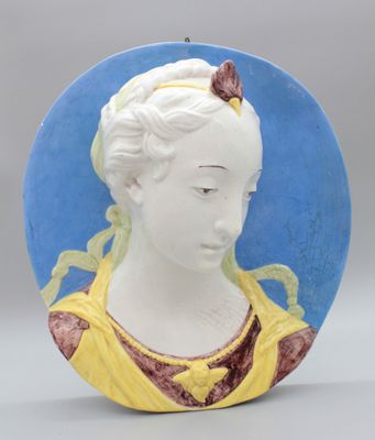 un portrait en céramique représentant une femme avec un papillon sur la tête