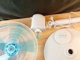 une table sur laquelle se trouvent un ventilateur et une télécommande
