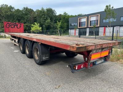 un camion à plateau garé sur un parking