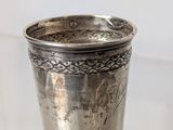 a silver cup that is sitting on a table