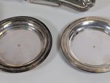 two silver plates and a silver spoon on a table