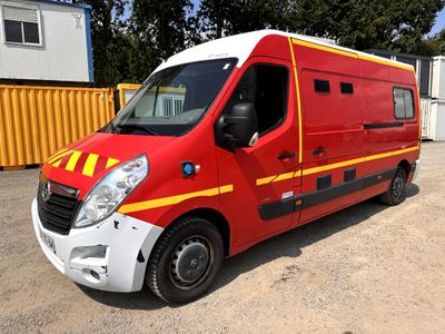 a red van with yellow stripes parked in a parking lot
