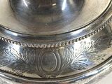 a silver bowl with a lid on a white table