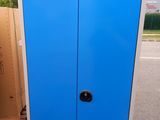 a blue cabinet sitting on a pallet in a parking lot