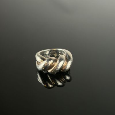 gros plan d'une bague en argent sur une surface noire