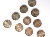 several coins are arranged in a triangle on a white surface