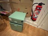 a green filing cabinet and a fire extinguisor in the corner of a room