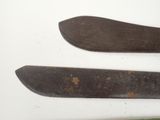 two old knives on a white surface next to each other