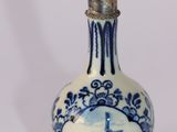 une petite bouteille bleue et blanche sur laquelle figure l'image d'un bateau