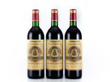 three bottles of wine sitting next to each other on a white surface