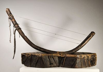 une sculpture représentant une corne d'animal, posée sur un socle en bois
