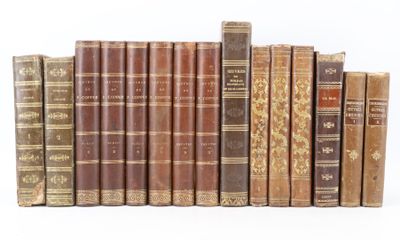 several old books are lined up in a row on a white surface