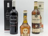 trois bouteilles d'alcool sont posées les unes à côté des autres sur une surface blanche